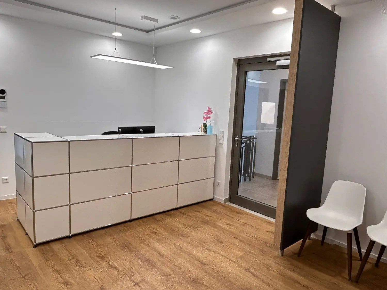 Facharztpraxis für Innere Medizin/Pneumologie – Diagnostik und Therapie - Empfangsbereich mit Schreibtisch, Stuhl und offener Tür